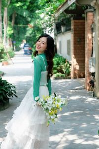 Captivating Smile: Young Woman in Green Embraces Nature's Serenity 1000019864-7