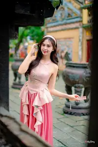 Graceful Woman in Pink Dress Amidst Ancient Heritage Charm 1000025280-7