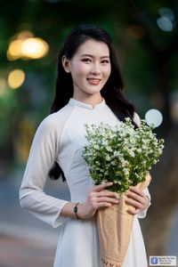 Elegant White Ao Dai: Graceful Vietnamese Girl's Beauty with a Pristine Floral Bouquet-2