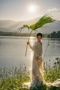 Golden Hour Serenity: Woman in White Dress Embracing Nature's Beauty by the Lake at Sunset.-7