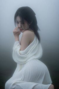 Ethereal Woman in White Dress Amidst Misty Haze Portrait-5