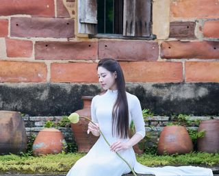 Elegant Vietnamese Woman in Traditional White Ao Dai, Gracing an Ancient Pathway | 1000017528-2