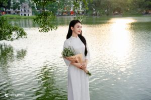 Elegant Vietnamese girl in traditional white Ao Dai by the lake, embodying cultural beauty-8