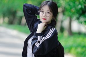 Radiant Youth: Girl in Uniform Playfully Blowing Bubbles in Lush Greenery 1000019736-6