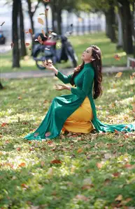 Vietnamese Grace: Elegant Woman in Green Ao Dai with Pink Lotus Flower 1000025232-6