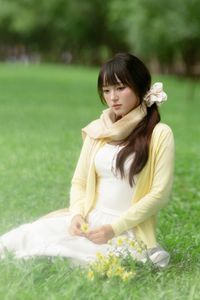 Pure Young Woman with Vibrant Yellow Flowers: Natural Beauty in a Lush Green Setting 1000019709-0