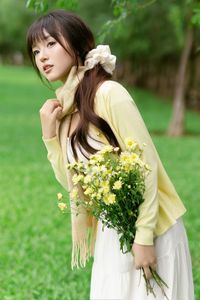 Pure Young Woman with Vibrant Yellow Flowers: Natural Beauty in a Lush Green Setting 1000019709-7