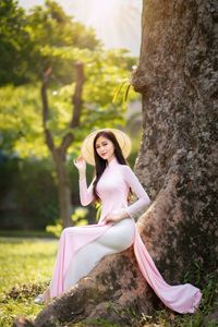 Elegant Vietnamese Woman in Pink Ao Dai Gracing a Sunny Park-6
