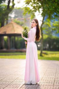 Elegant Vietnamese Woman in Pink Ao Dai Gracing a Sunny Park-7
