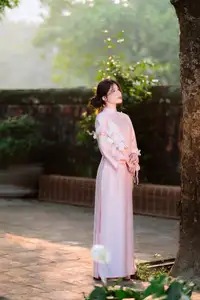 Elegant Vietnamese Beauty: Young Woman Gracefully Posing in Pink Ao Dai with White Orchids 1000026874-11