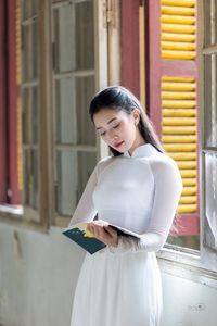 Graceful Vietnamese Girl in White Ao Dai by Window, Celebrating Traditional Beauty-7